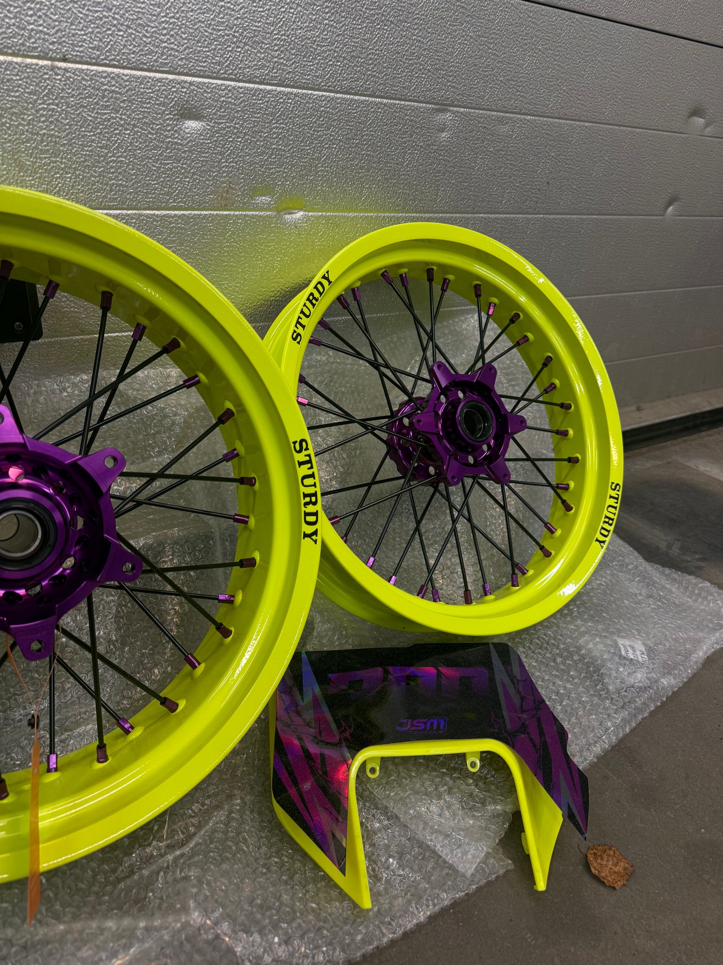 Sturdy custom supermoto wheels – neon yellow rims, purple hubs