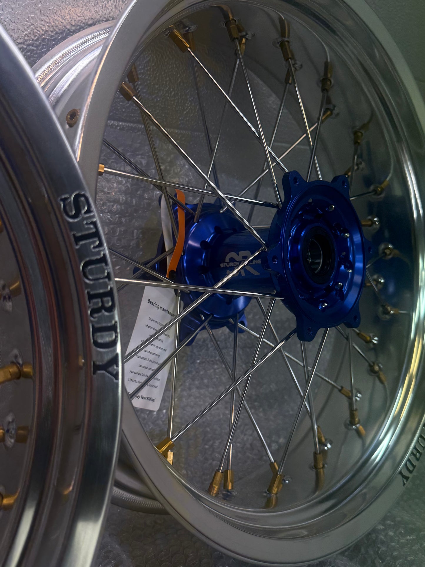 Sturdy custom supermoto wheel – silver rim, blue hub, gold nipples