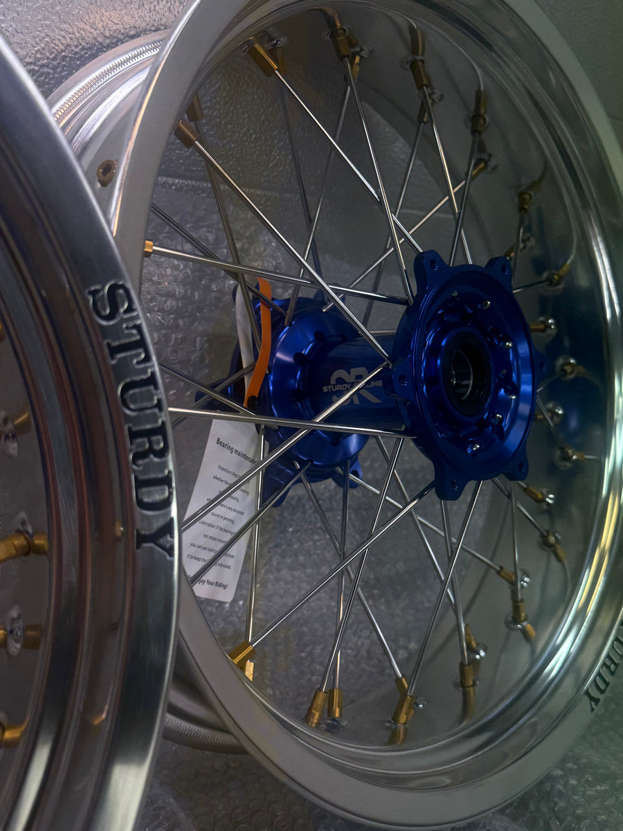 Sturdy custom supermoto -vanne – hopea kehä, sininen napa, kullanväriset nipat